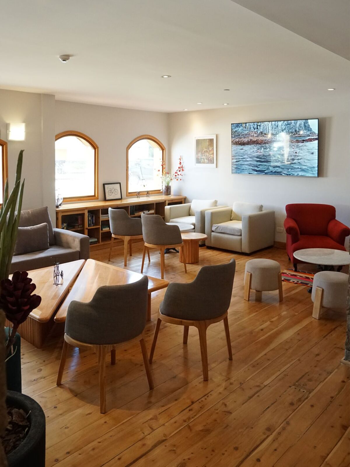 Lounge with sofas, upholstered chairs, wooden tables and arched windows