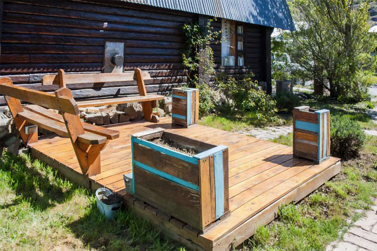 Wooden deck with benches and planters in the garden