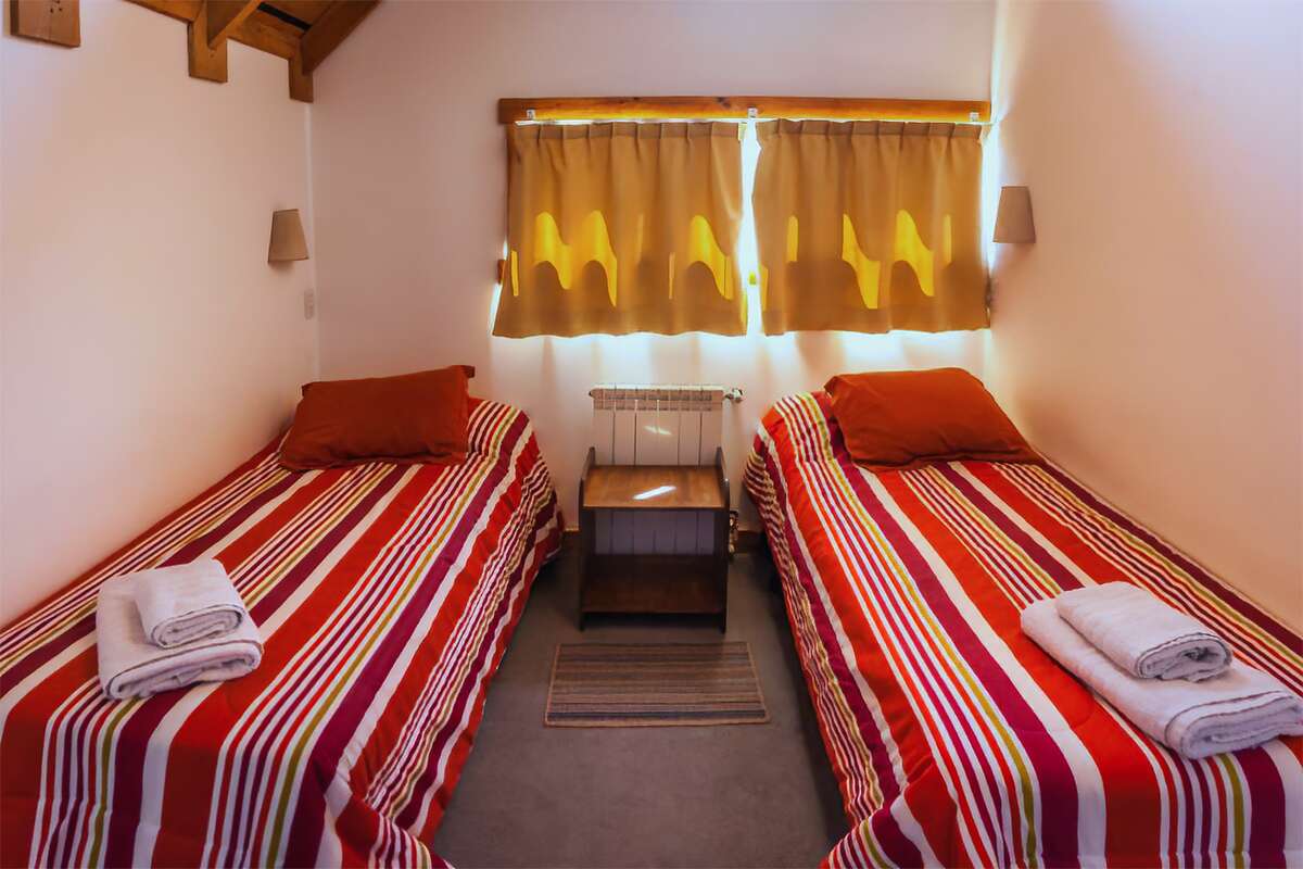 Bedroom with two single beds and towels on the beds