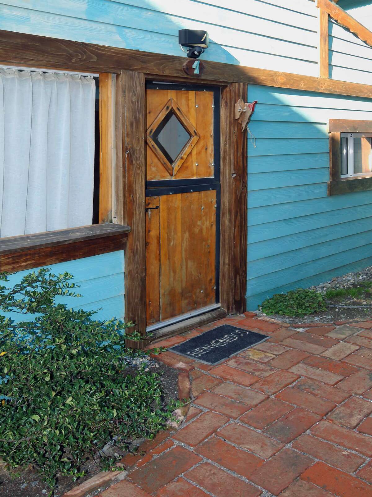 Wooden cabin door with a welcome mat