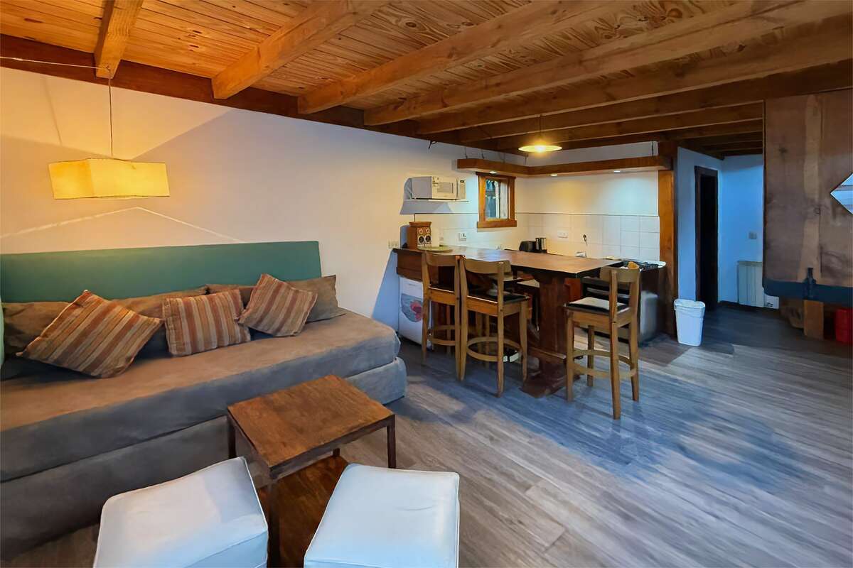 Living-dining room with a sofa, coffee table, bar and open kitchen