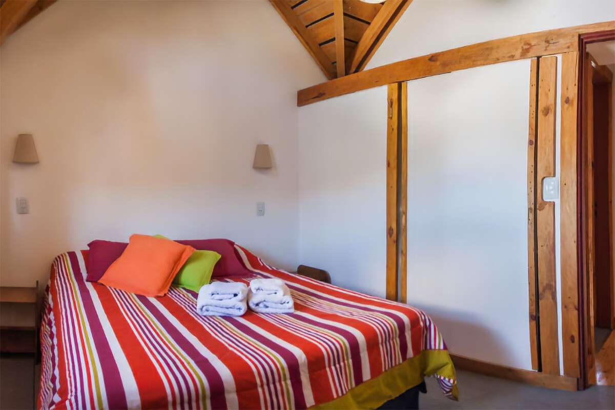 Bedroom with a double bed, colorful cushions and towels