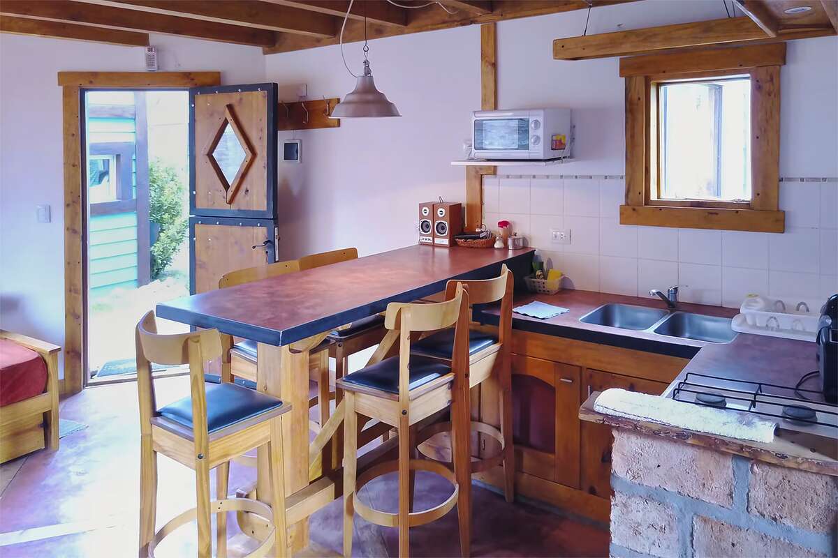 Kitchen with a bar, stools and the front door