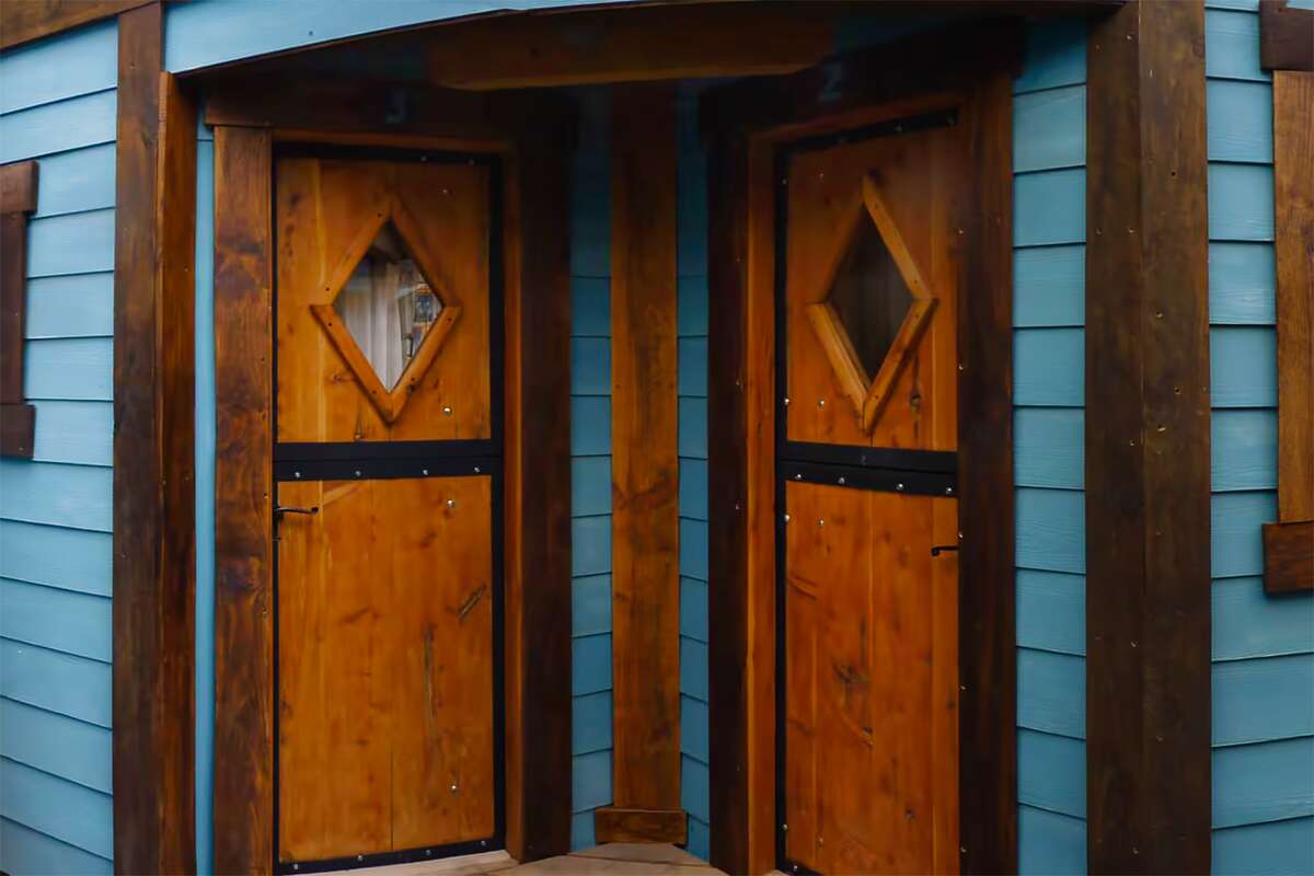 Two wooden cabin doors on the light-blue façade