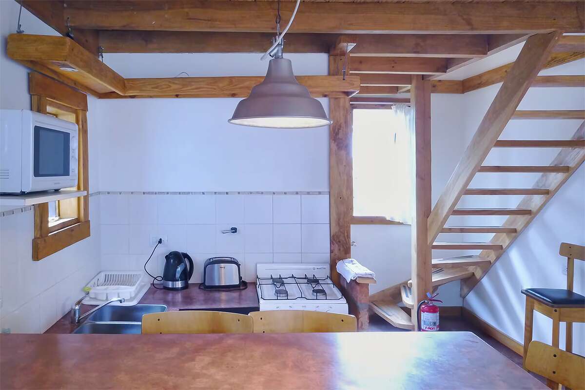 Kitchen with gas stove, electric kettle and toaster, and stairs to the upper floor