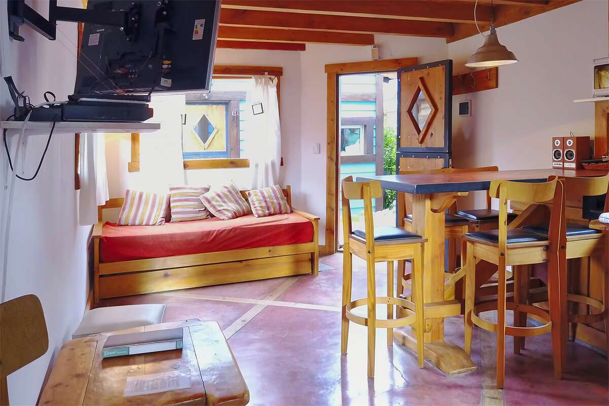 Living room with sofa bed, TV and a bar with stools