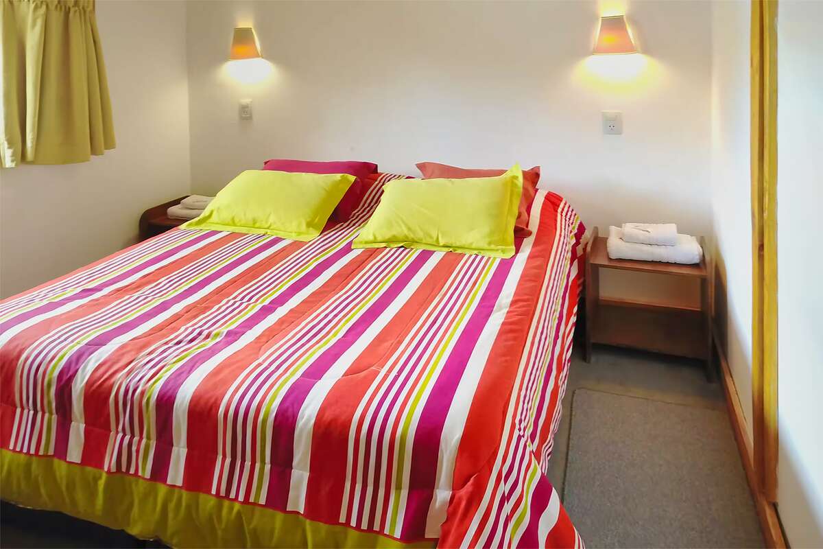 Double bed with colorful cushions and nightstands