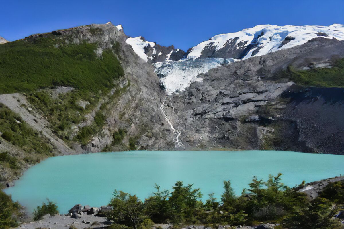 Laguna turquesa al pie del Glaciar Huemul, rodeada de bosque de lengas