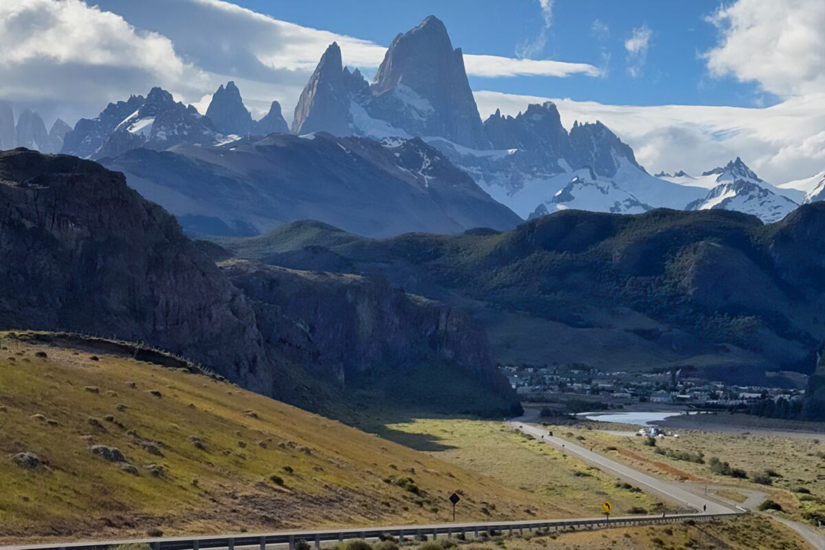 El Fitz Roy y el Cerro Torre sobre el valle, con El Chaltén y la ruta de acceso abajo
