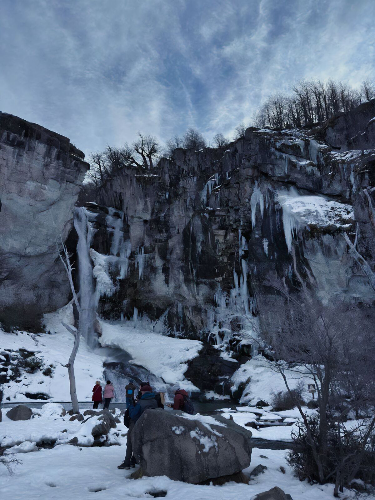 Chorrillo del Salto congelado en invierno, con visitantes en la nieve