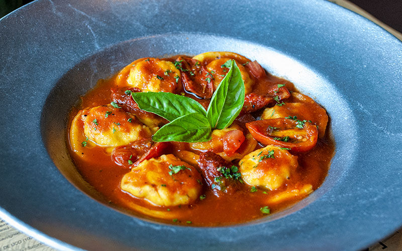 Sorrentinos en salsa de tomate con hojas de albahaca