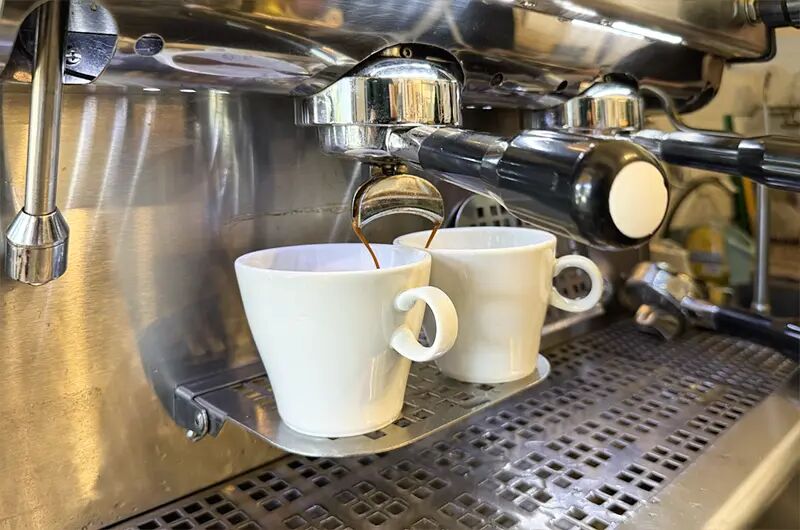 Dos tazas recibiendo espresso de la máquina