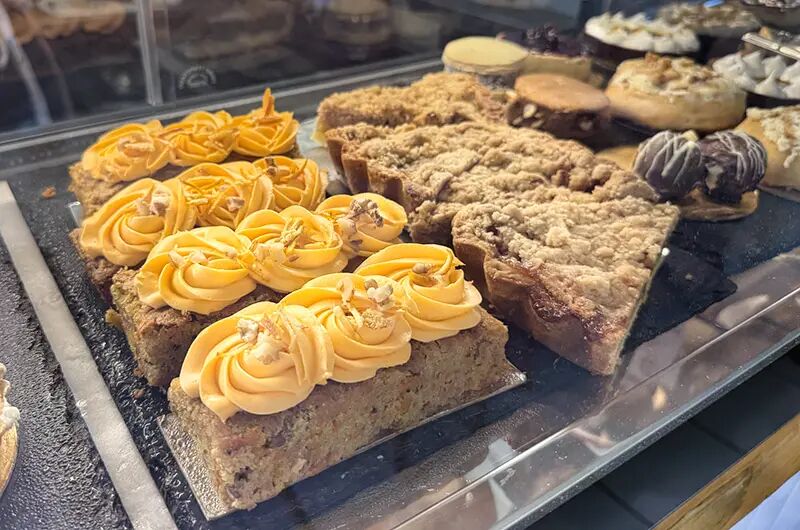 Bandeja de carrot cake con copos de crema y crumble en la vitrina