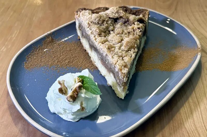 Porción de crumble de manzana con crema y nueces