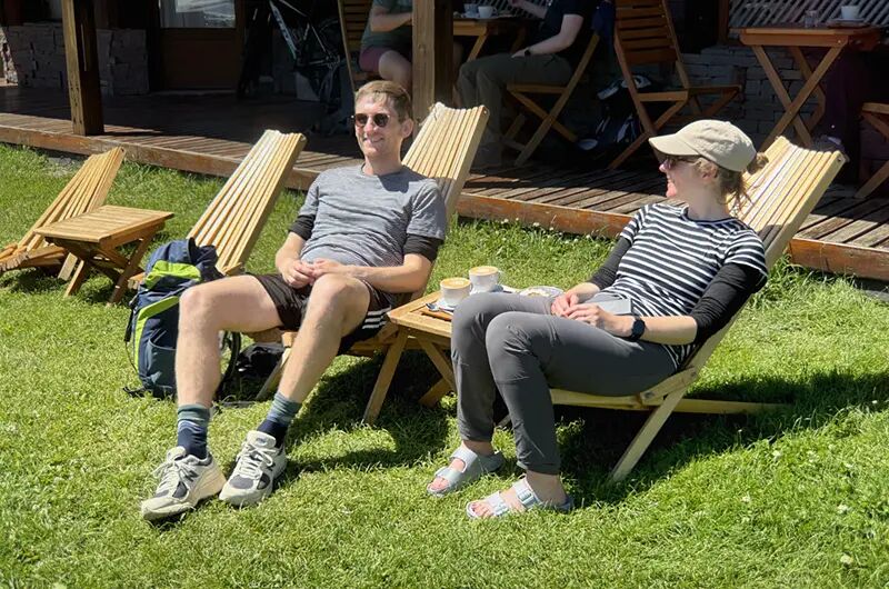 Pareja en reposeras de madera en el jardín