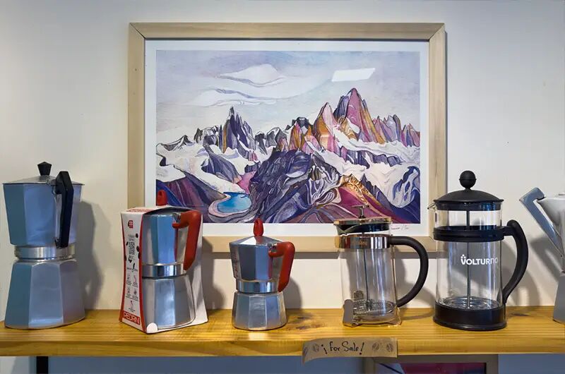 Cafeteras moka y prensa francesa frente a un cuadro del Fitz Roy