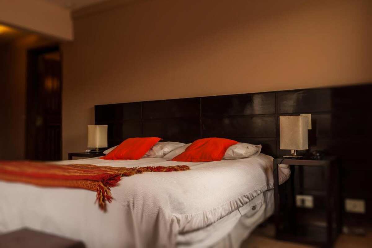Double bed with red cushions, nightstands and lamps