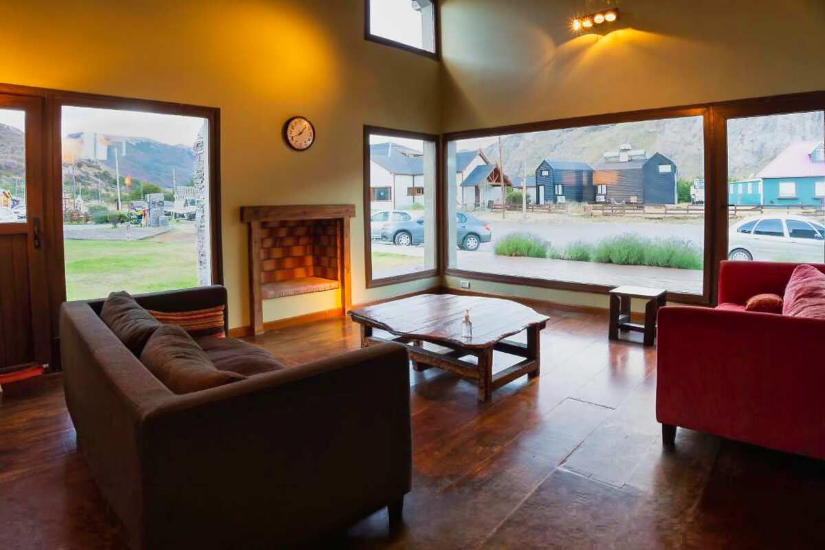 Lounge with sofas, a fireplace and large windows facing the street