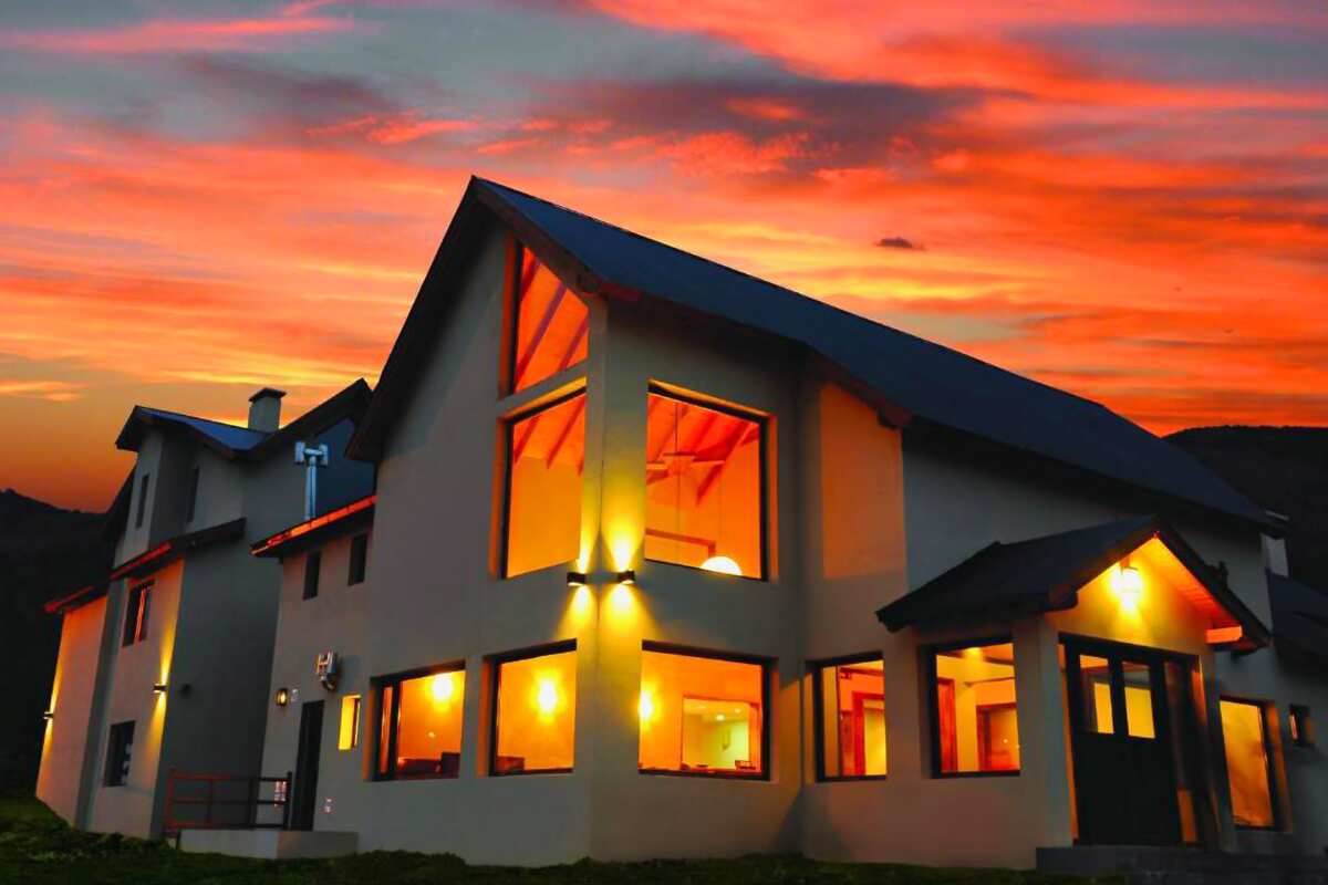The hotel with its lights on under a red sunset sky