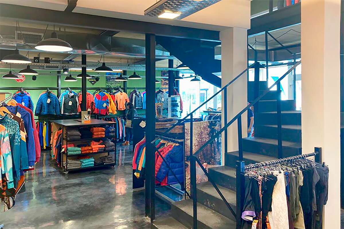 Escalera metálica al primer piso junto a percheros de ropa de abrigo